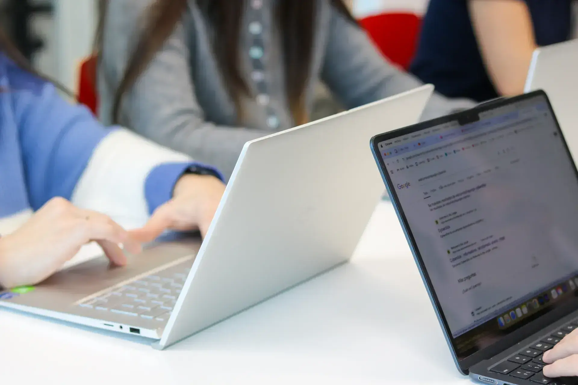 Two laptops, with one open on Google